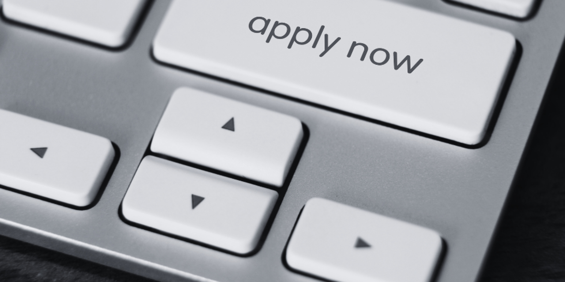 Black and white keyboard displaying "apply now" button