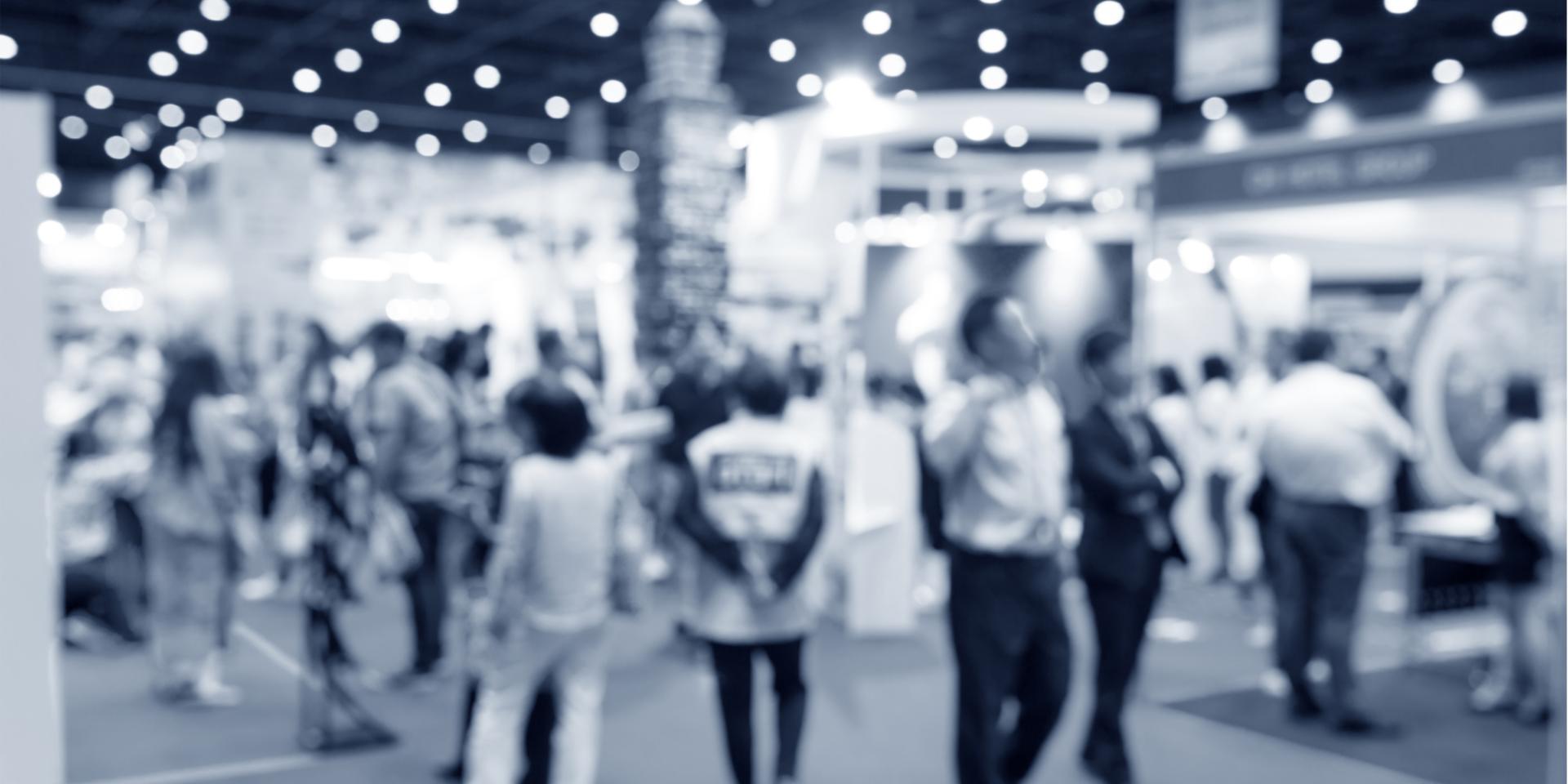 A blurred image of people walking around an event