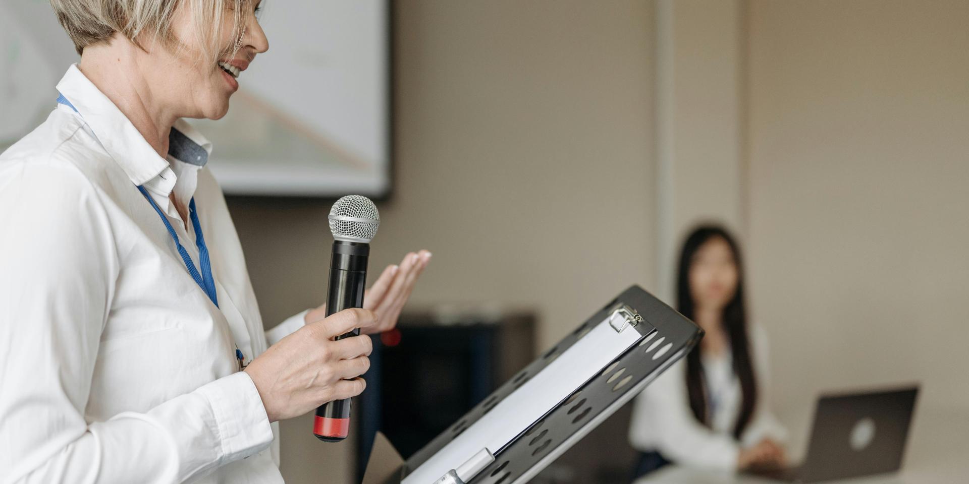 Person at music stand holds microphone