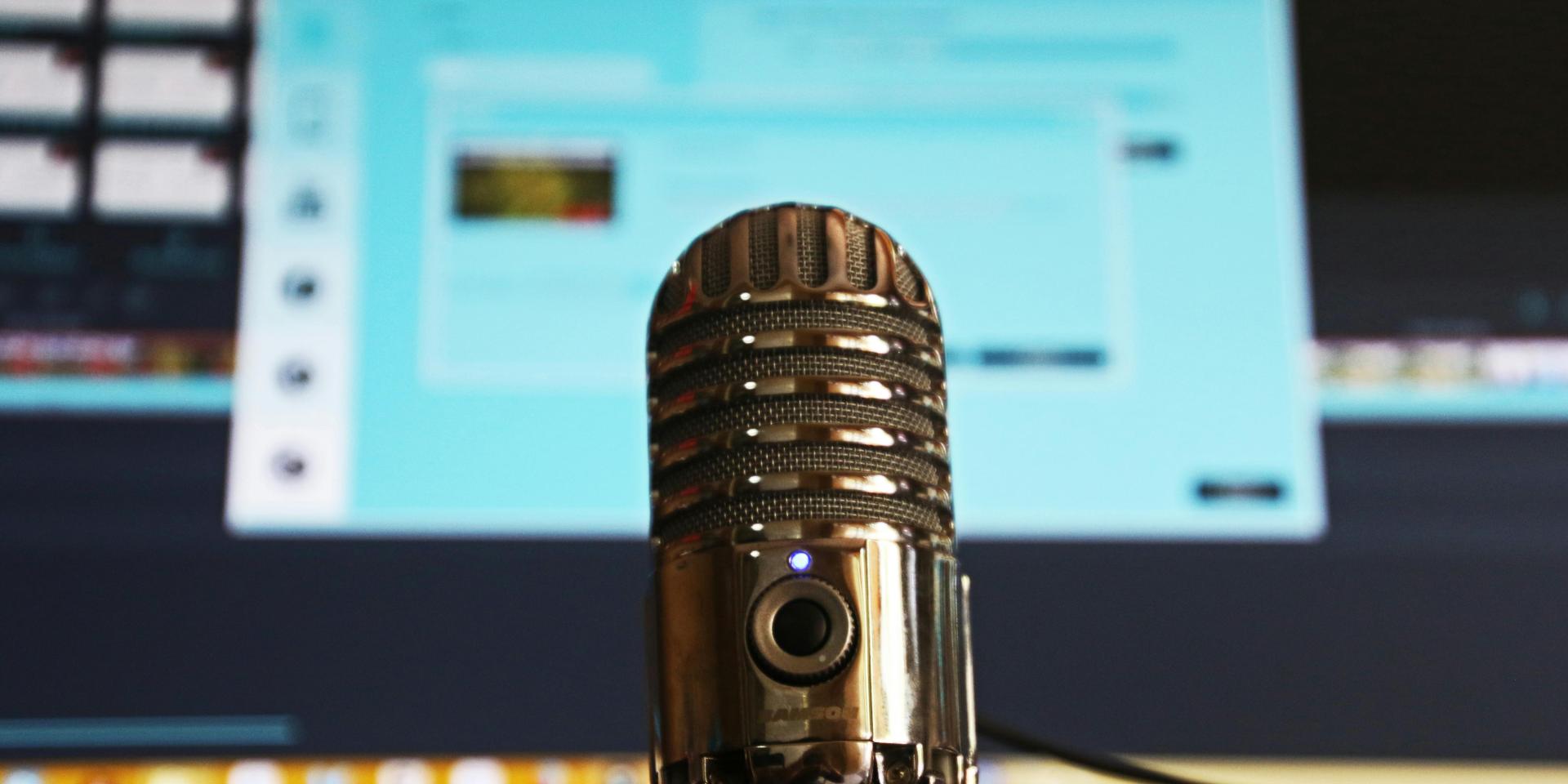 Podcast microphone with a computer in the background
