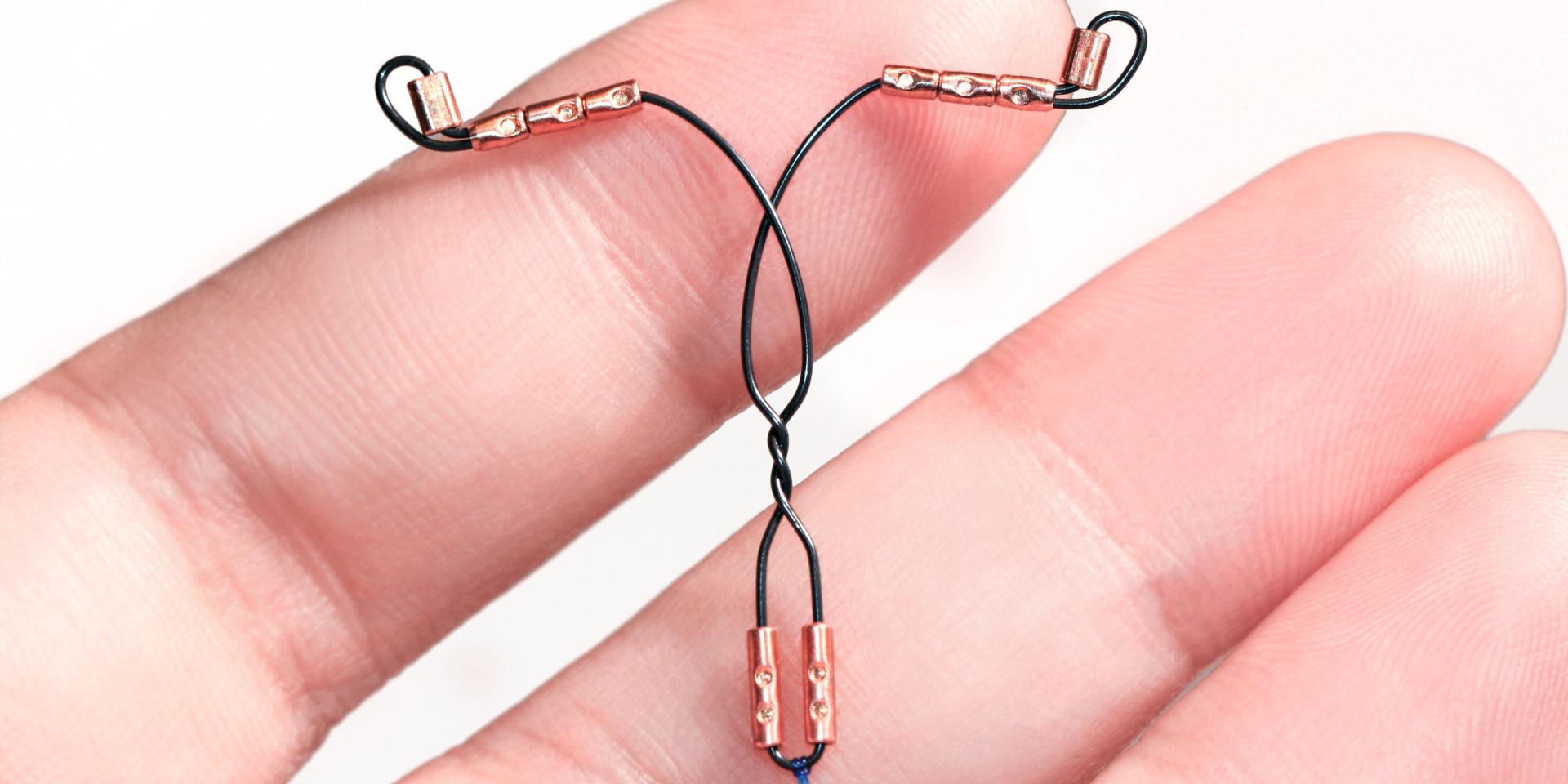 Wire and copper T-shaped IUD in someone's hand