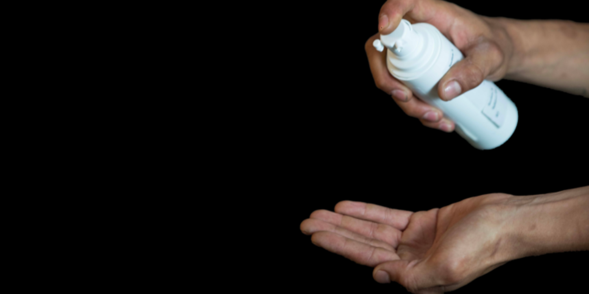 Hands spraying a white bottle