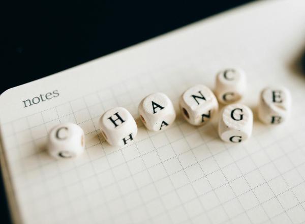 Multiple letter dice showing the words "Change" and "Chance" on an open notebook