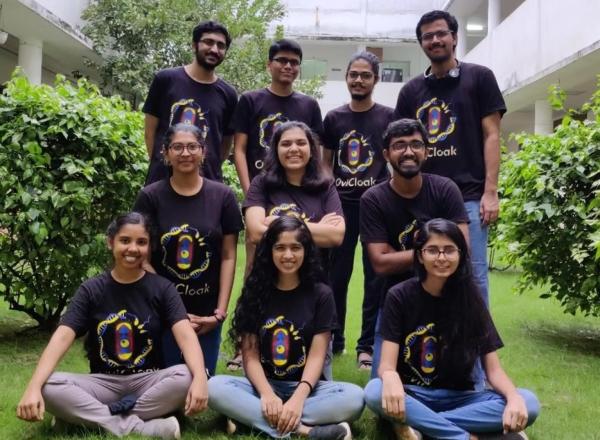 Group of 10 students pose in matching shirts outdoors