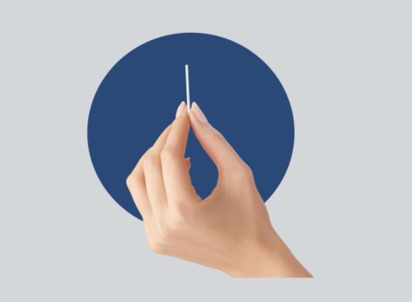 Hand holding an implant rod with blue circle behind