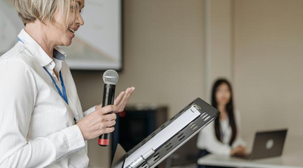 Person at music stand holds microphone